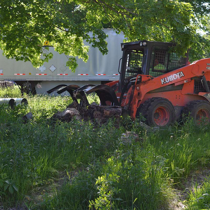 Kubota skid steer with low profile grapple bucket